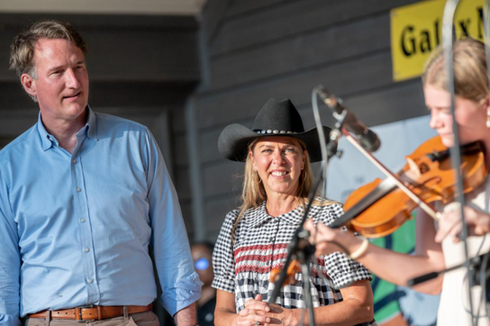 Le gouverneur et la première dame regardent un élève jouer du violon