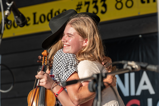 Le gouverneur et la première dame regardent un élève jouer du violon