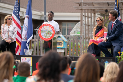 Spirit4-Event-photo1 : un étudiant au podium pendant que le gouverneur et la première dame écoutent.